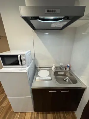 a small kitchen with a sink and a microwave at \u548c\u306e\u6953cottage\u7b2c\u4e8c301 \u65b0\u5bbf\u6b4c\u821e\u4f0e\u753a\u8fd1\u96a3 in Tokyo