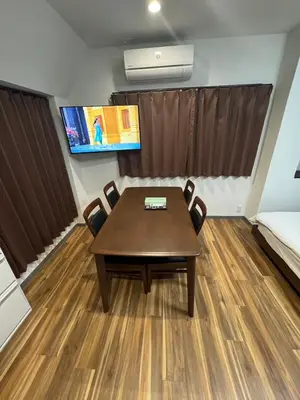 a dining room with a table and a flat screen tv at \u548c\u306e\u6953cottage\u7b2c\u4e8c301 \u65b0\u5bbf\u6b4c\u821e\u4f0e\u753a\u8fd1\u96a3 in Tokyo