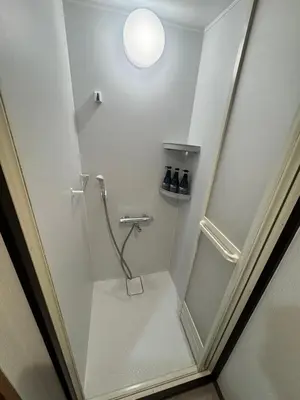 a bathroom with a shower in a white room at \u548c\u306e\u6953cottage\u7b2c\u4e8c301 \u65b0\u5bbf\u6b4c\u821e\u4f0e\u753a\u8fd1\u96a3 in Tokyo