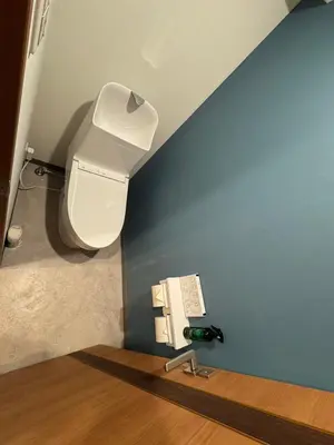 a bathroom with a toilet and a blue wall at \u548c\u306e\u6953cottage\u7b2c\u4e8c301 \u65b0\u5bbf\u6b4c\u821e\u4f0e\u753a\u8fd1\u96a3 in Tokyo