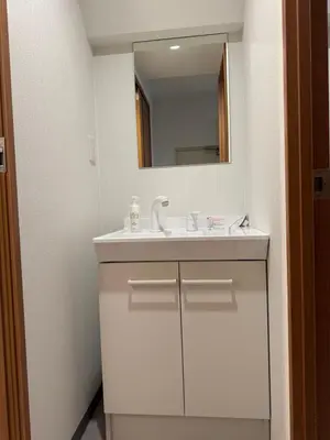 a white bathroom with a sink and a mirror at \u548c\u306e\u6953cottage\u7b2c\u4e8c301 \u65b0\u5bbf\u6b4c\u821e\u4f0e\u753a\u8fd1\u96a3 in Tokyo