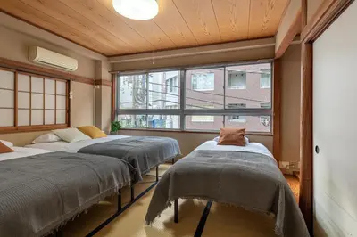 three beds in a room with windows at \u5165\u82392\u4e01\u76ee\u6238\u5efa\u3066 in Tokyo