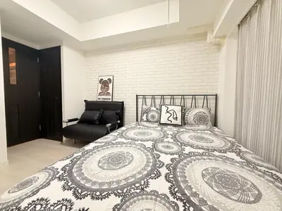 a bedroom with a large bed and a black chair at S6 Shibuya center-350m from Shibuya st ation in Tokyo