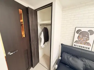 a hallway with a door and a black leather couch at S6 Shibuya center-350m from Shibuya st ation in Tokyo