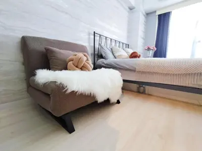 a bedroom with a couch and a bed with a white pillow at Z57\u65b0\u5bbf\u6700\u4e2d\u5fc3 \u6771\u65b0\u5bbf\u7ad95\u5206-Shinjuku center 5 mins to St, Max 3P \u76f4\u8fbe\u65b0\u5bbf \u6d89\u8c37 \u8868\u53c2\u9053 \u6c60\u888b \u4e0a\u91ce \u4ee3\u4ee3\u6728 \u94f6\u5ea7 \u539f\u5bbf in Tokyo