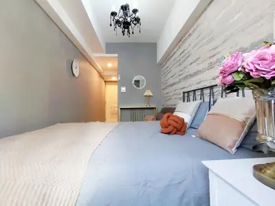 a bedroom with a large bed with pink flowers on it at Z57\u65b0\u5bbf\u6700\u4e2d\u5fc3 \u6771\u65b0\u5bbf\u7ad95\u5206-Shinjuku center 5 mins to St, Max 3P \u76f4\u8fbe\u65b0\u5bbf \u6d89\u8c37 \u8868\u53c2\u9053 \u6c60\u888b \u4e0a\u91ce \u4ee3\u4ee3\u6728 \u94f6\u5ea7 \u539f\u5bbf in Tokyo