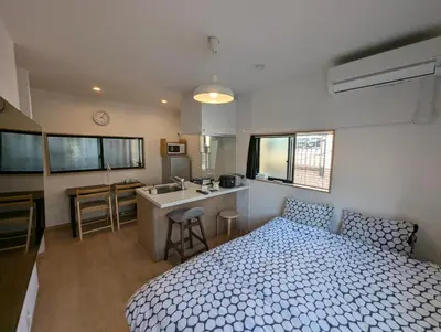 a bedroom with a bed and a kitchen with a sink at Yahiro House in Tokyo