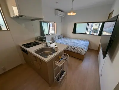 a small kitchen with a sink and a bed at Yahiro House in Tokyo