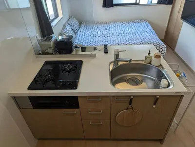 a kitchen with a sink and a stove at Yahiro House in Tokyo
