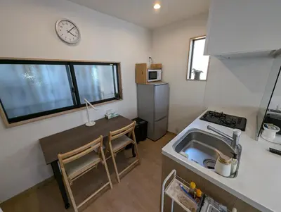 a small kitchen with a sink and a clock on the wall at Yahiro House in Tokyo
