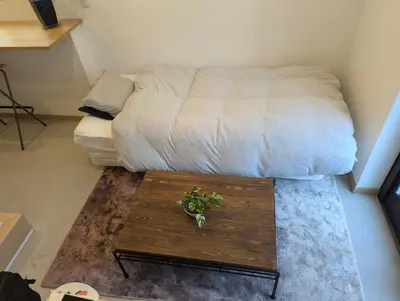 a room with a bed and a coffee table at Yahiro House in Tokyo