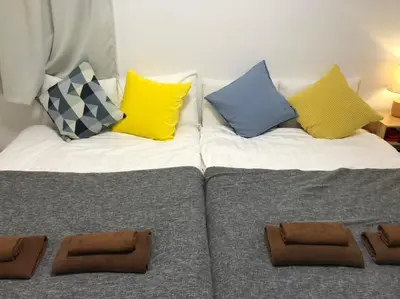 a bed with colorful pillows on top of it at \u30ea\u30d6\u30b7\u30c6\u30a3\u9326\u7cf8\u753a\u53c2\u756a\u9928\u4e0a\u5c64\u968e\u773a\u671b\u826f\u597d\u5317\u6b27\u30eb\u30fc\u30e0, Akihabara 6mins, Tokyo 8 mins, Direct to Narita Airport \u6210\u7530\u7a7a\u6e2f\u76f4\u9054 in Tokyo