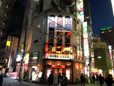 a building with neon signs in a city at night at \u30ea\u30d6\u30b7\u30c6\u30a3\u9326\u7cf8\u753a\u53c2\u756a\u9928\u4e0a\u5c64\u968e\u773a\u671b\u826f\u597d\u5317\u6b27\u30eb\u30fc\u30e0, Akihabara 6mins, Tokyo 8 mins, Direct to Narita Airport \u6210\u7530\u7a7a\u6e2f\u76f4\u9054 in Tokyo
