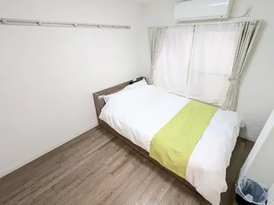 a small bedroom with a bed and a window at SEIRYU Bldg in Tokyo
