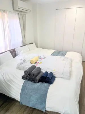 a bedroom with a white bed with towels on it at SEIRYU Bldg in Tokyo