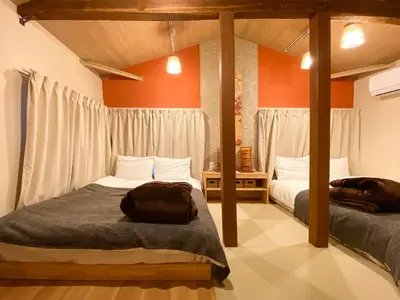two beds in a room with orange walls at The Villa Ebisu RED\u60e0\u6bd4\u5bff\u99c5\u5f92\u6b658\u5206\u9759\u304b\u306a\u4f4f\u5b85\u5730 in Tokyo