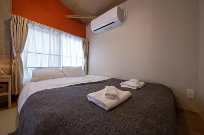 a bedroom with a bed with towels on it at The Villa Ebisu RED\u60e0\u6bd4\u5bff\u99c5\u5f92\u6b658\u5206\u9759\u304b\u306a\u4f4f\u5b85\u5730 in Tokyo