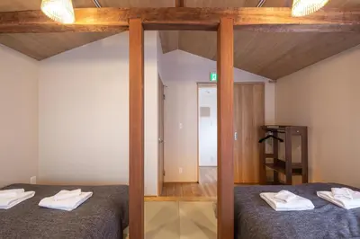 a bedroom with two beds with wooden posts at The Villa Ebisu RED\u60e0\u6bd4\u5bff\u99c5\u5f92\u6b658\u5206\u9759\u304b\u306a\u4f4f\u5b85\u5730 in Tokyo