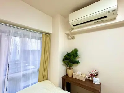a bedroom with a bed and a window with a air conditioner at B2-Shinjuku center 3mins to ST Max 4P-\u65b0\u5bbf\u4e2d\u5fc3 \u5927\u4e45\u4fdd\u99c53\u5206\u949f \u8d85\u7ea7\u5546\u5708\u4ea4\u901a\u67a2\u7ebd \u6b65\u884c\u5230\u65b0\u5bbf\u6b4c\u821e\u4f0e\u753a \u5c71\u624b\u7dda\u76f4\u8fbe\u6e0b\u8c37\u9280\u5ea7\u6c60\u888b in Tokyo