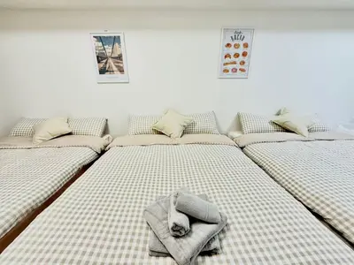 a room with four beds with towels on them at \u6c60\u888b Aurora 7 in Tokyo