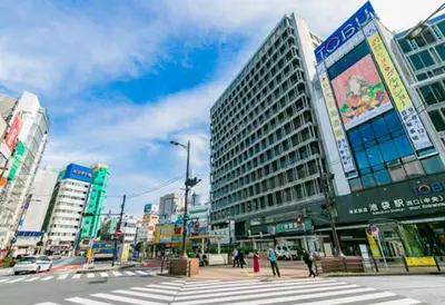 a busy city street with tall buildings and a crosswalk at \u6c60\u888b Aurora 7 in Tokyo