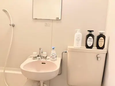 a bathroom with a sink and a toilet with bottles on it at \u6c60\u888b Aurora 7 in Tokyo