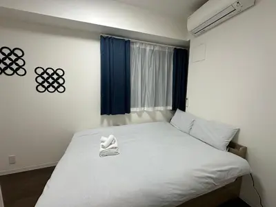 a bedroom with a white bed with a window at SOLASIA residence \u5317\u4e0a\u91ce402 in Tokyo