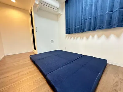 a bedroom with a blue bed in a room at SOLASIA residence \u5317\u4e0a\u91ce402 in Tokyo