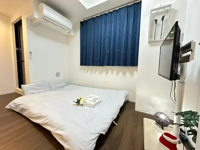 a bedroom with a white bed and a tv at SOLASIA residence \u5317\u4e0a\u91ce402 in Tokyo