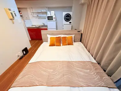 a small bedroom with a bed with two orange pillows at NC-302Yamanote Line shinjuku \u9ad8\u7530\u99ac\u5834 5mins walk Hostel! \u9ad8\u901fWi-fi! Waseda in Tokyo