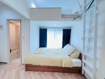 a bedroom with a bed and a window and shelves at Sugamo 1F-TS0334 in Tokyo