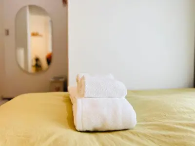 a pile of towels sitting on top of a bed at Sugamo 1F-TS0334 in Tokyo