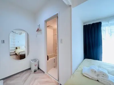 a white bedroom with a mirror and a bed at Sugamo 1F-TS0334 in Tokyo