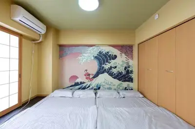 a bedroom with a bed with a painting on the wall at \u5409\u7965\u5929 in Tokyo