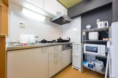 a kitchen with a sink and a stove and a microwave at \u5409\u7965\u5929 in Tokyo
