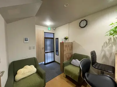 a waiting room with two chairs and a clock on the wall at \u5e73\u5b89\u65c5\u9986\u7537\u58eb\u8ff7\u4f60\u5355\u8eab\u516c\u5bd3 in Tokyo