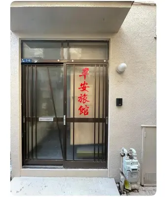 a building with a glass door with writing on it at \u5e73\u5b89\u65c5\u9986\u7537\u58eb\u8ff7\u4f60\u5355\u8eab\u516c\u5bd3 in Tokyo