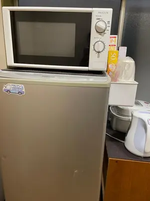 a microwave sitting on top of a refrigerator at \u5e73\u5b89\u65c5\u9986\u7537\u58eb\u8ff7\u4f60\u5355\u8eab\u516c\u5bd3 in Tokyo