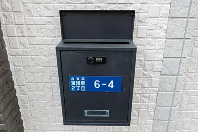 a black parking meter on a brick wall at Asakusa Stay Hotel in Tokyo