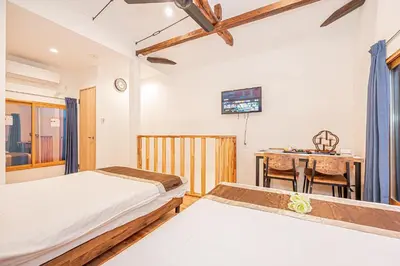 a bedroom with two beds and a desk and a table at Asakusa Stay Hotel in Tokyo