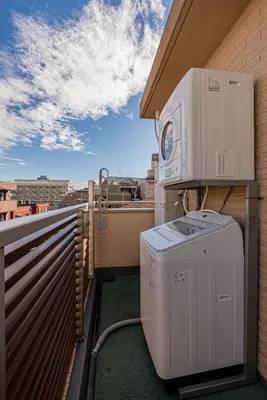 a balcony with a washing machine on the side of a building at \u6e0b\u8c37\u99c5\u5f92\u6b69 10\u5206 \u4ee3\u5b98\u5c717\u5206 3LDK90m \u9ad8\u7d1a\u4f4f\u5b85\u5c4b\u4e0a\u4ed8\u304d \u96fb\u8eca\u3067\u8868\u53c2\u90532\u5206\u9280\u5ea715\u5206\u65b0\u5bbf5\u5206 in Tokyo