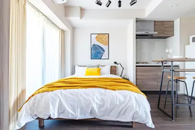 a bedroom with a bed with a yellow blanket at Dash Living Osaki in Tokyo