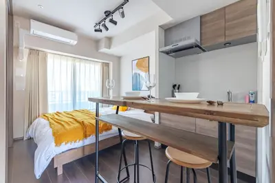 a kitchen with a table and a bed in a room at Dash Living Osaki in Tokyo