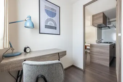 a room with a desk with a chair and a kitchen at Dash Living Osaki in Tokyo