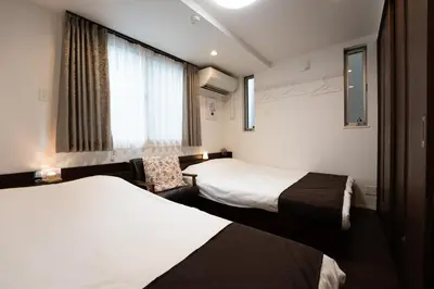 a hotel room with two beds and a window at Takasago Utopia Hotel in Tokyo