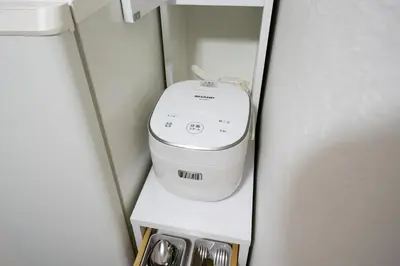 a washing machine in the corner of a room at Takasago Utopia Hotel in Tokyo