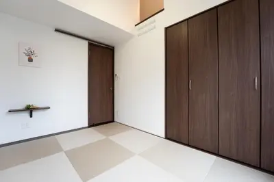 an empty room with wooden cabinets and a tiled floor at Takasago Utopia Hotel in Tokyo