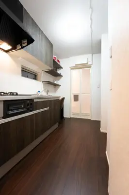 an empty kitchen with wooden flooring and a counter top at Takasago Utopia Hotel in Tokyo