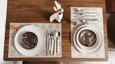 a wooden table with two plates and silverware on it at Takasago Utopia Hotel in Tokyo
