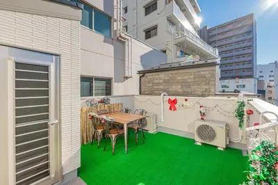 a balcony with a table and chairs on a green floor at \u65b0\u7b51Jr\u5c71\u624b\u7dda\u9daf\u8c37\u5f92\u6b653\u5206\u76f4\u8fbe\u4e0a\u91ce \u79cb\u53f6\u539f \u65b0\u5bbf \u6da9\u8c37 \u6c60\u888b \u539f\u5bbf \u94f6\u5ea7 \u6210\u7530\u673a\u573a\u72ec\u680b\u56db\u5c42110\u5e73\u522b\u5885 in Tokyo